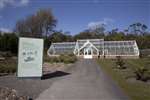 Renewable energy sign and glasshouse at Logan Botanic Garden, Galloway